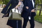 L'actrice française Catherine Deneuve (g) et un invité non identifié viennent assister au défilé Louis Vuitton à Paris, le 7 octobre 2015