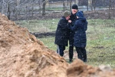 Des personnes se tiennent près d'une fosse commune dans la localité ukrainienne de Boutcha (nord-ouest de kiev), le 3 avril 2022 