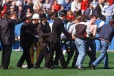 Des policiers et des supporters aident à évacuer des blessés du stade d'Hillsborough (Royaume-Uni) le 15 avril 1989, où une bousculade a coûté la vie à 96 personnes