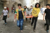 Des Syriens portent un blessé après des frappes aériennes contre le quartier de Ferdous à Alep, le 26 avril 2016 