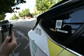 Une utilisatrice scanne un code QR pour entrer dans un robotaxi autonome sans chauffeur à Wuhan, le 1er août 2024 dans la province chinoise du Hubei
