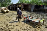 Une femme marche près de sa maison endommagée par la crue d'une rivière dans le village de Jindi, dans le district de Charsadda, dans le nord-ouest du Pakistan, le 1er septembre 2022