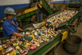 Un employé vérifie les canettes usagées pour le recyclage dans un hangar de l'entreprise Latasa Garimpeiro Urbano, le 26 juin 2023 à Sao Paulo, au Brésil