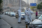 Des membres des services de secours près du lieu où un homme est mort en pleine rue à Wuhan, le 30 janvier 2020 en Chine