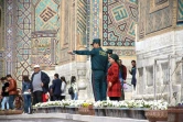 Des membres de la nouvelle "Police des touristes" renseignent des visiteurs de la ville de Samarcande, le 28 mars 2018 en Ouzbékistan