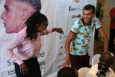 Le chanteur belge Stromae fait un pas de danse avec l'une des ses cousines lors d'une conférence de presse à Kigali le 17 octobre 2015