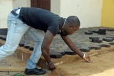Un Camerounais pave le sol avec des pavés fabriqués avec des déchets plastiques recyclés, le 1er février 2016 à Yaoundé 