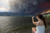 Une habitante observe la fumée des feux qui menacent la ville de West Kelowna, dans la province canadienne de la Colombie-Britannique, le 17 août 2023