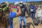 Les premiers touristes à atterrir sur l'île de Pâques depuis plus de deux ans sont accueillis avec un collier de fleurs, à l'aéroport de international de Mataveri, à Hanga Roa, au Chili, le 4 août 2022