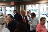 Le candidat républicain à la présidentielle américaine Donald Trump écoute un homme dans un café boulangerie à Miami, le 27 septembre 2016 en Floride