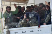 Des combattants des Forces démocratiques syriennes (FDS) font le V de la victoire en rentrant du front en Syrie, où ils sont sur le point de chasser le groupe Etat islamique de son dernier bout de terre dans le village de Baghouz (est), le 19 mars 2019 