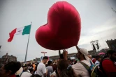 Un homme avec un ballon en forme de coeur rouge attend le "cri" de l'Indépendance sur la place du Zocalo à Mexico, dimanche 15 septembre 2024, jour de fête nationale au Mexique