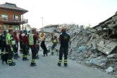 Des pompiers et leurs chiens inspectent les décombres, le 27 août 2016 à Amatrice, trois jours après le séisme