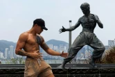 Un fan prend la pose devant la statue de Bruce Lee sur le front de mer à Hong Kong, le 15 juillet 2023