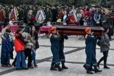 Des secouristes du ministère russe des situations d'urgence portent le cercueil d'une victime de la fusillade dans un lycée, lors d'une cérémonie funéraire à Kertch, en Crimée, le 19 octobre 2018