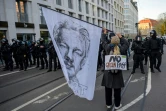 Un manifestant contre le pass sanitaire tient un drapeau représentant Julian Assange le 6 novembre 2021 à Leipzig, en Allemagne