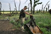 Un soldat ukrainien inspecte les débris d'un char russe, près de Mykolaïv, dans le sud de l'Ukraine, le 12 juin 2022
