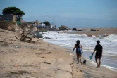 Des promeneurs sur la plage d'Atafona, cité balnéaire qui disparaît peu à peu sous l'océan, le 7 février 2022 au Brésil