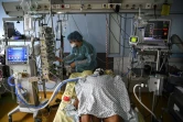 Une infirmière soigne un patient atteint du Covid-19 sous assistance respiratoire, à l'hopital  AP-HP Cochin à Paris, le 18 mars 2021