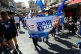 Des sympathisants du Likoud, le parti du Premier ministre israélien Benjamin Netanyahu, font campagne dans le marché Mahane Yehuda à Jérusalem, le 19 mars 2021, à quelques jours des législatives