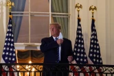 Le président américain Donald Trump enlève son masque à son arrivée à la Maison Blanche le 5 octobre 2020 après trois jours d'hospitalisation