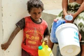 Un enfant yéménite attend son tour pour remplir de l'eau dans un camp de déplacés installé à Khokha pour les habitants ayant fui la ville proche de Hodeida, cible d'une offensive gouvernementale, le 22 juin 2018
