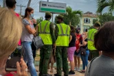 Des policiers cubains surveillent la file d'attente devant une banque de La Havane, le 4 janvier 2021