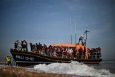 Des migrants récupérés en mer par un navire de la Royal National Lifeboat Institution (RNLI) alors qu'ils tentaient de traverser La Manche, débarquent sur une plage de Dungeness, le 15 juin 2022 au sud-est de l'Angleterre