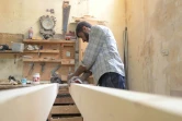 Un menuisier syrien effectue des mesures dans l'atelier du fabriquant de meubles Youssef al-Qabouni à Saqba, près de Damas le 13 août 2018