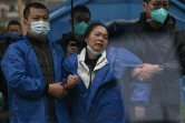 Une proche en larmes arrrive à l'entrée de la zone du crash d'un  Boeing 737-800 de la China Eastern Airlines, le 24 mars 2022 à Wuzhou, dans le sud de la Chine 