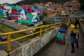 Des habitants du quartier pauvre de Mariscal Sucre empruntent la passerelle qui surplombe l'avenue reliant le centre de Bogota aux quartiers riches du nord de la capitale, le 1er septembre 2016