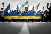 Des manifestants agitent des drapeaux ukrainiens et européens à Toulouse lors d'une manifestation contre l'invasion russe de l'Ukraine le 6 mars 2022.