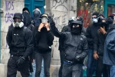 Des protestataires lancent des pierres contre la police anti-émeutes le 4 juin 2016 à Paris pendant une marche des "antifascistes" à la mémoire du militant d'extrême gauche Clément Méric