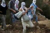 Un jeune palestinien est évacué par ses camarades après avoir été touché lors d'affrontements avec la police israélienne à Beit El (Cisjordanie), le 10 octobre 2015