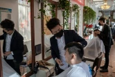 Des coiffeurs portent un masque de protection dans un salon de Pékin le 23 janvier 2020