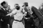 Une Parisienne manifeste sa joie en embrassant le général de Gaulle qui défile sur les Champs-Elysées après la libération