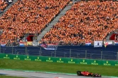 La Ferrari du Monégasque Charles Leclerc, passe devant la foule de supporteurs néérlandais, venus soutenir Max Verstappen, au GP de F1 d'Autriche, le 10 juillet 2022 à Spielberg