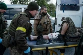 Des soldats ukrainiens évacuent un blessé près de Lyssytchansk, proche du front de l'est ukrainien, le 10 mai 2022