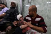 Un Palestinien tente de réconforter un enfant blessé dans un bombardement israélien, à l'hôpital al-Najjar de Rafah, dans le sud de la bande de Gaza, le 24 mars 2024