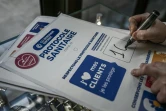 Un patron de commerce prépare une affiche du protocole sanitaire à respecter pour la réouverture le 28 novembre 2020 des commerces non essentiels, le 25 novembre 2020 à Bordeaux