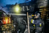 Un pompier lutte contre un incendie dans un immeuble résidentiel après une frappe russe sur Kherson en Uktraine, le 22 avril 2024