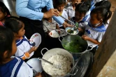 Des écoliers prennent un petit-déjeuner avant d'entrer en classe, le 8 juillet 2022 dans la province de Siem Reap, au Cambodge