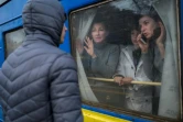 Une famille à bord d'un train d'évacuation fait ses adieux à un jeune homme resté sur place, le 6 mars 2022 en gare d'Odessa, dans le sud de l'Ukraine
