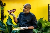 Le maître-chocolatier et entrepreneur Ralph Leroy pose avec l'une de ses plus emblématiques créations, la sculpture d'un escarpin, dans les ateliers de la chocolaterie Makaya de Petionville (Haïti) le 23 décembre 2020