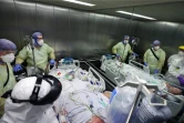 Des membres du personnel soignant transportent un malade du Covid-19 pour un scanner au CHU de Magdeburg, en Allemagne, le 10 décembre 2021
