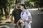Un couple de militaires ukrainiens, Kristina et Vitali Orlich, pendant leur mariage dans la ville de Droujkivka, dans l'est de l'Ukraine, le 12 juin 2022