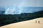 Deux personnes sur la la dune du Pilat d'où l'on voit la fumée s'élever de l'incendie qui s'est déclaré à La Teste-de-Buch (Gironde), le 16 juillet 2022 