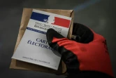Une personne vote, gantée, le 15 mars 2020 à Paris