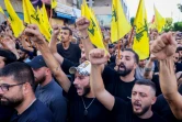 Des partisans du Hezbollah lèvent le poing lors des funérailles à Beyrouth des membres du mouvement libanais tués dans une frappe israélienne dans la banlieue sud de Beyrouth, le 21 septembre 2024