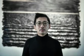 L'artiste d'origine vetnamienne Bao Vuong pose devant un de ses tableaux, à la galerie A2Z à Paris le 13 janvier 2022